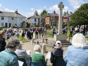 Residents sing around the memorial cross